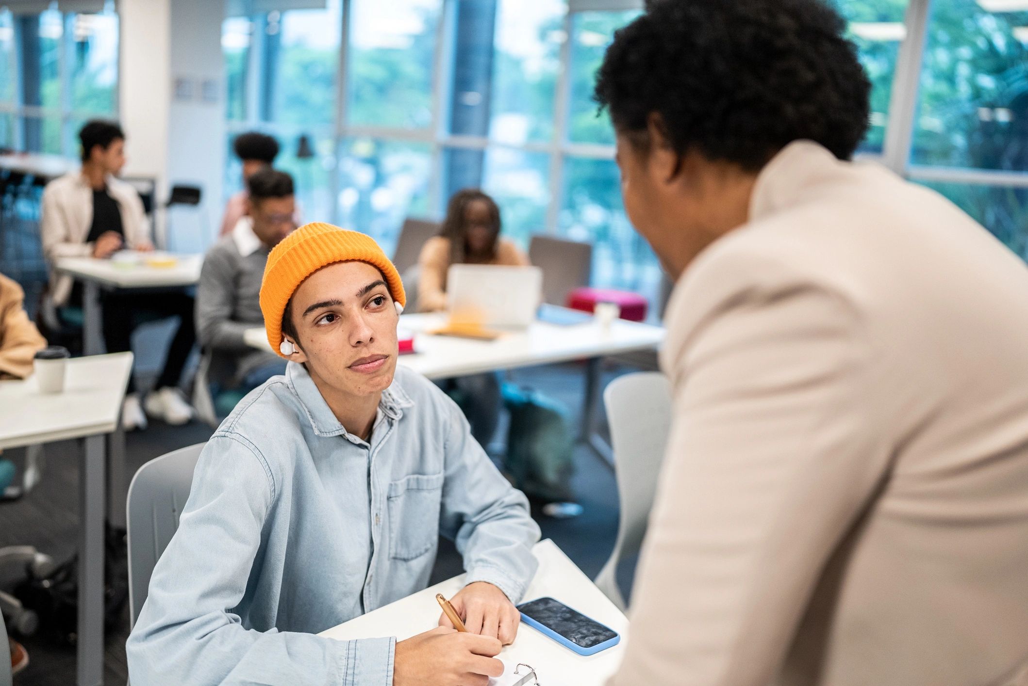 Teacher speaking with a student in a classroom